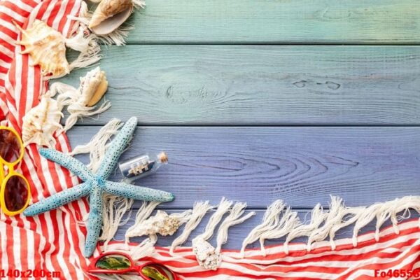 summer background: fringed pareos, seashells, sun goggles, starfish on a blue wooden background