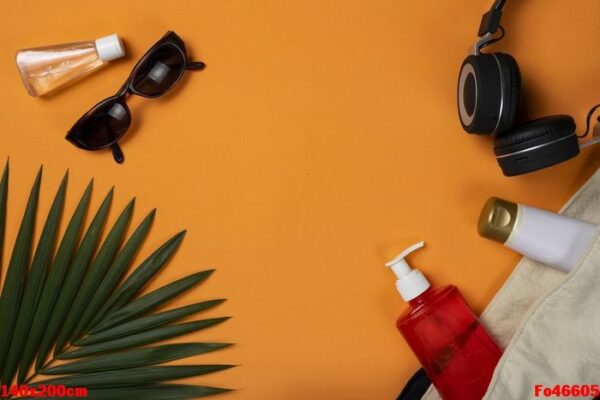 sunglasses and beach objects on orange summer beach background