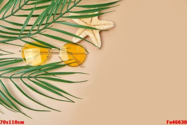 sunglasses and palm leaves top view on beige background