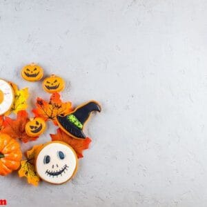 halloween background with cookies, pumpkin, leaves