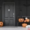 carved,pumpkins,,bats,and,spiders,near,black,front,door,of