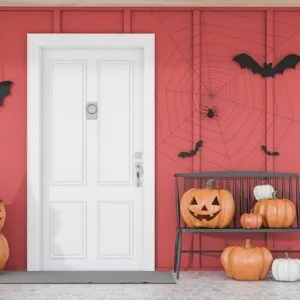 carved,pumpkins,,bats,and,spiders,near,white,front,door,of