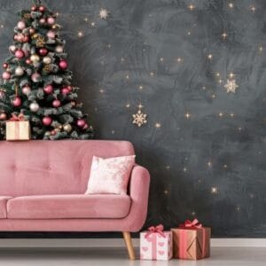 stylish pink sofa decorated for christmas with christmas tree and ornaments