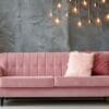 stylish pink sofa decorated for christmas with christmas tree and ornaments