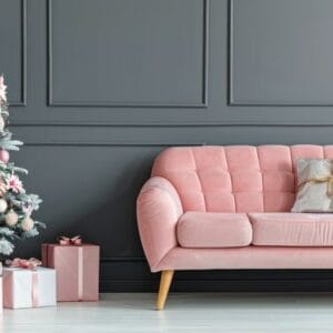 stylish pink sofa decorated for christmas with christmas tree and ornaments