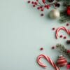 red ornaments and candy cane on green background