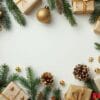 festive christmas gifts surrounded by evergreen branches and gold ornaments on white background