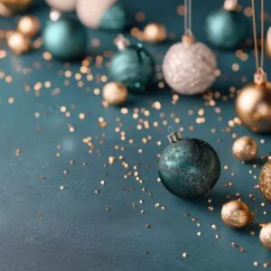 colorful christmas ornaments and glitter on dark background during holiday season