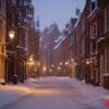 a snowy street with a few lights on