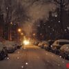 a snowy street with cars parked on both sides