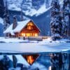 snow covered cabin by a frozen lake in a mountainous winter land