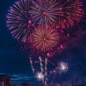 bright fireworks exploding in the night sky over a cityscape, re