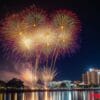 bright fireworks exploding in the night sky over a cityscape, re