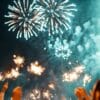 fireworks illuminating a festive scene, with people holding spar