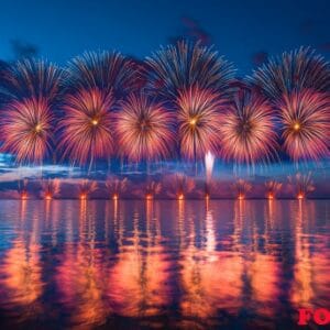 fireworks reflecting on the water as they explode in the sky, cr