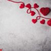 red yarn heart shaped on the wall background