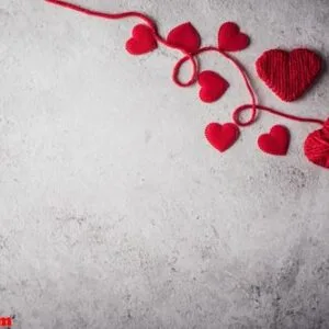 red yarn heart shaped on the wall background