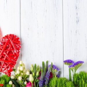 background with spring flowers and decoratiove wooden heart