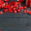 gift box with red hearts on wooden table