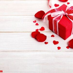 valentine background of gift box and rose petals on white wood.