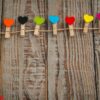 red paper heart hanging on wood background .