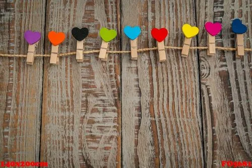 red paper heart hanging on wood background .