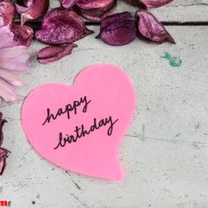 happy birthday note in heart shape paper with pink flowers